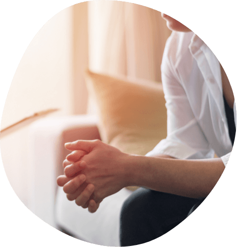 Person sitting in chair with hands together in front of them