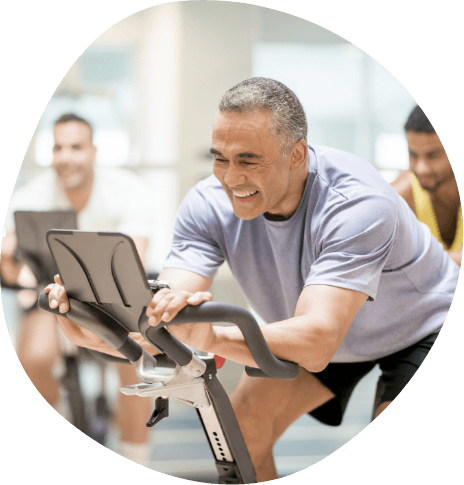 Smiling man exercising on machine at gym