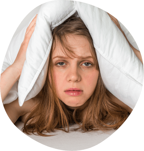 Exhausted woman covering the top of her head with pillow
