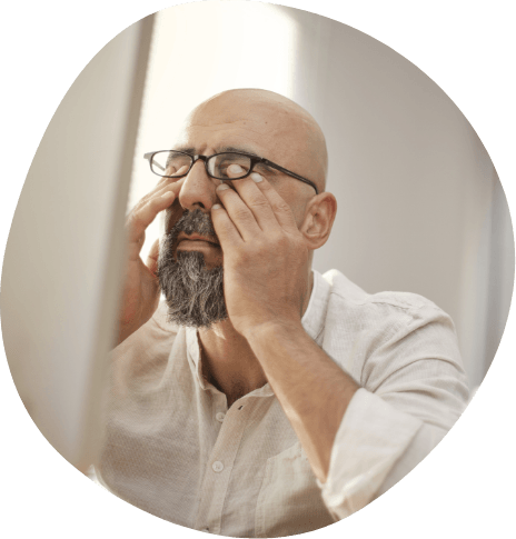 Tired man with glasses rubbing his eyes