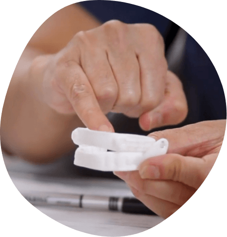 Person holding a white oral appliance