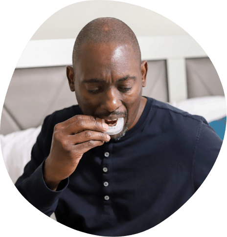 Man placing a white oral appliance in his mouth