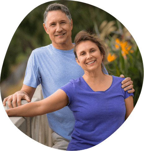 Man and woman in blue shirt smiling together outdoors