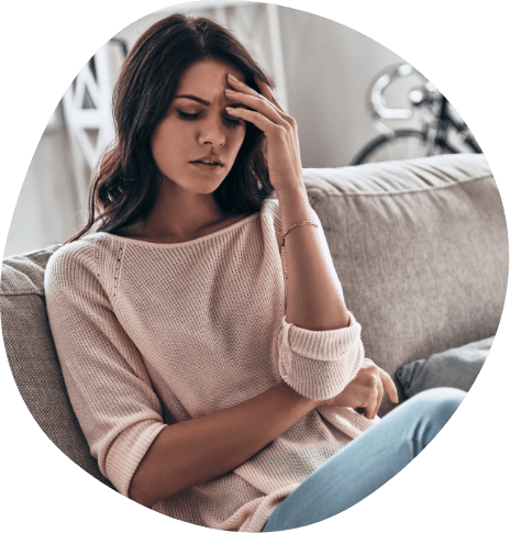 Frustrated young woman on couch resting her head in her hand