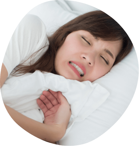 Woman lying in bed clenching her teeth