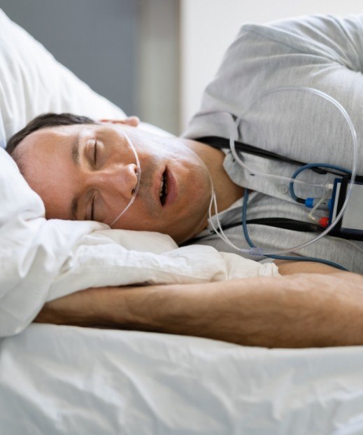 Man sleeping while hooked up to electrodes for sleep testing in Frisco