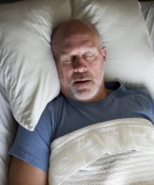 Older man sleeping soundly after snoring treatment in Frisco
