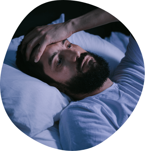 Bearded man lying awake in bed