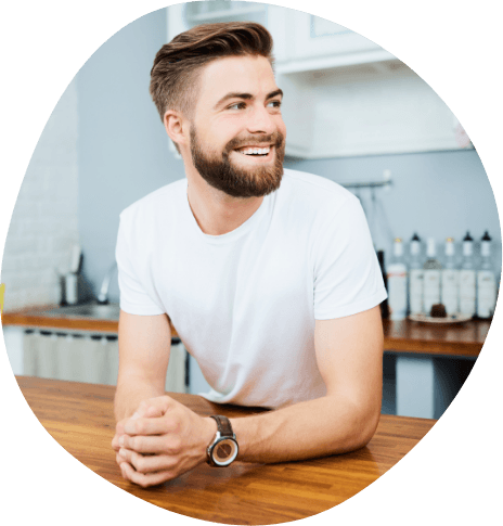 Smiling man leaning on kitchen counter