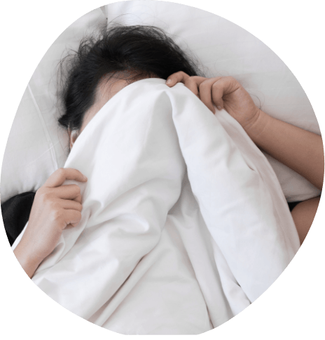 Man in bed covering his face with white sheets
