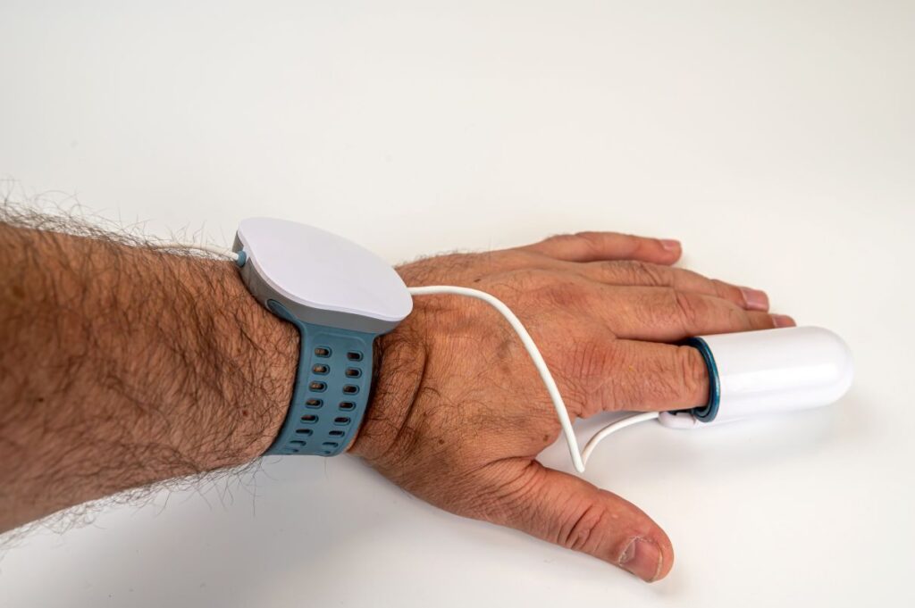 A man’s hand with a sleep test device attached to it